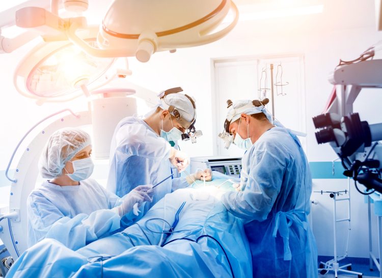 Spinal surgery. Group of surgeons in operating room with surgery equipment. Laminectomy. Modern medical background